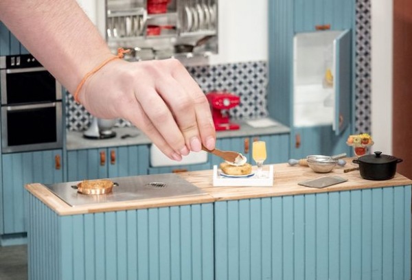 A lány, aki babaházban készít miniatűr ételeket A lány, aki babaházban készít miniatűr ételeket